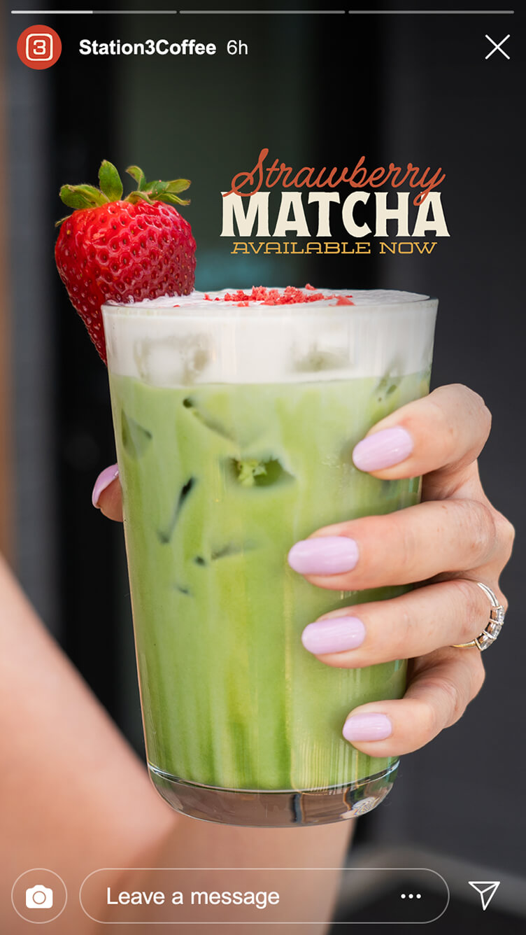 Hand holding iced strawberry matcha latte topped with whipped foam, red sprinkles, and a fresh strawberry, with promo text overlay.